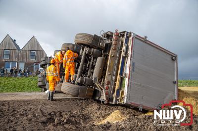 Vrachtwagen geladen met mais beland op zijkant dwars over de Kamperzeedijk N760 nadat hij in de berm terecht was gekomen. - © NWVFoto.nl