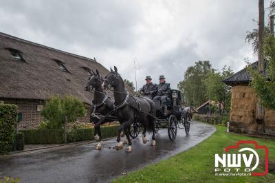 Met regenkleding aan op de bok tijdens de historische koetsentocht Elburg. - © NWVFoto.nl
