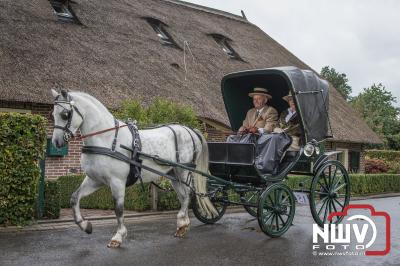 Met regenkleding aan op de bok tijdens de historische koetsentocht Elburg. - © NWVFoto.nl