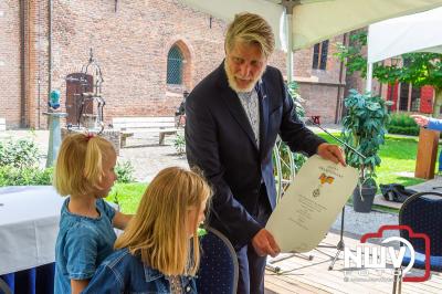 De burgemeester van Elburg laat familieleden de lintjes opspelden tijdens een gezellig samen zijn in de kloostertuin Elburg. - © NWVFoto.nl
