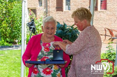 De burgemeester van Elburg laat familieleden de lintjes opspelden tijdens een gezellig samen zijn in de kloostertuin Elburg. - © NWVFoto.nl
