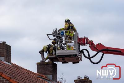 Brandweer veegt schoorsteenkanaal na dat deze inbrand had gestaan. - © NWVFoto.nl