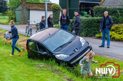 Berger moet auto weer op de weg zetten, nadat de bestuurster bij het achteruit rijden in een greppel belandde. - © NWVFoto.nl