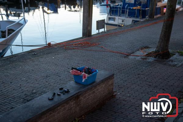 Toeristen vissen springgranaat uit haven Elburg tijdens het magneetvissen. - © NWVFoto.nl